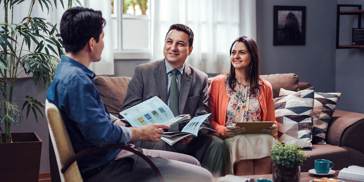 A brother, accompanied by his wife, using the “Enjoy Life Forever!” book to conduct a Bible study with a man.