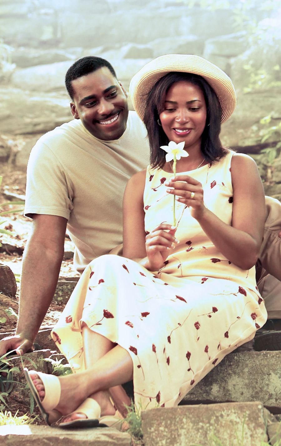 አንድ ባልና ሚስት በአትክልት ቦታ ተቀምጠው አንዲትን አበባ በአድናቆት ሲመለከቱ