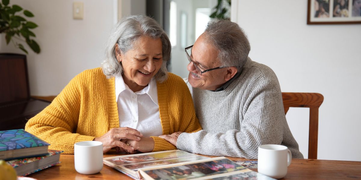 A happy older couple looking through a photo album together.