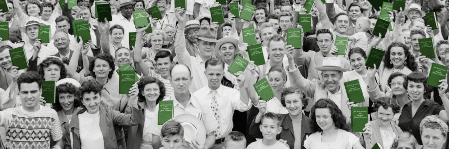 A crowd of assembly delegates holding up their copy of The New World Translation of the Christian Greek Scriptures