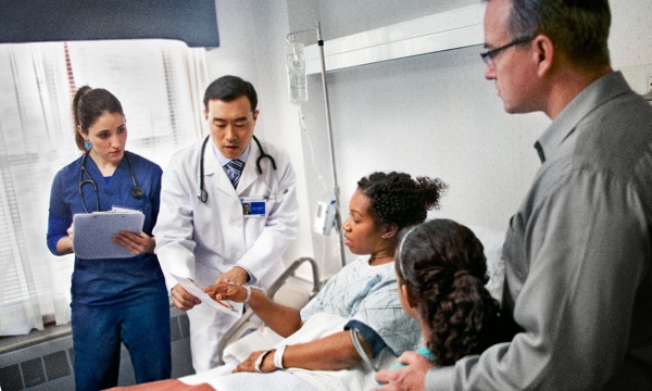 A Christian sister in a hospital bed talks with medical professionals