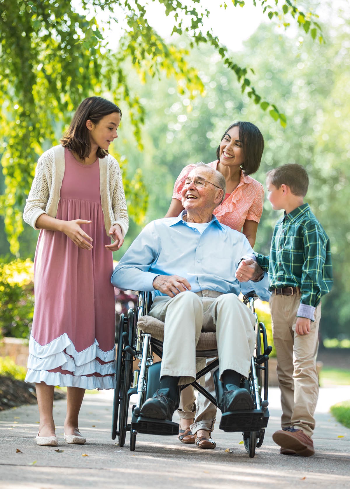 A sick man in a wheelchair is surrounded by loved ones
