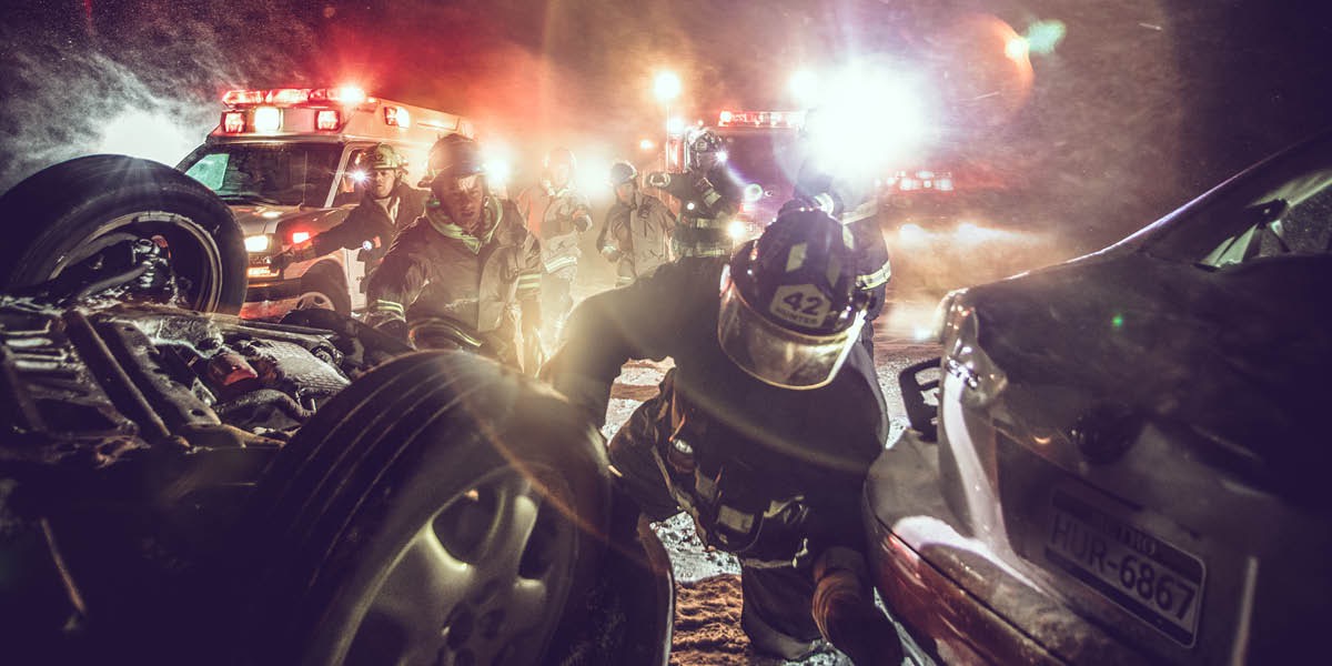 একটা গাড়ি দুর্ঘটনার পর উদ্ধারকারীরা উদ্ধারকাজ চালাচ্ছে