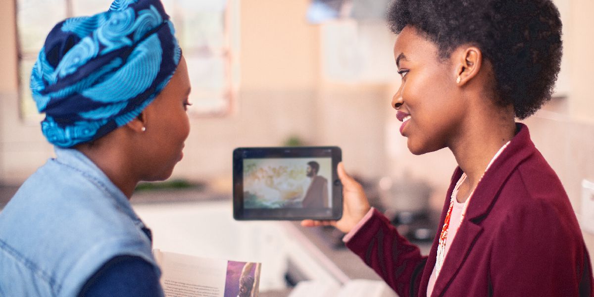 Una hermana mostrando un video a su estudiante de la Biblia