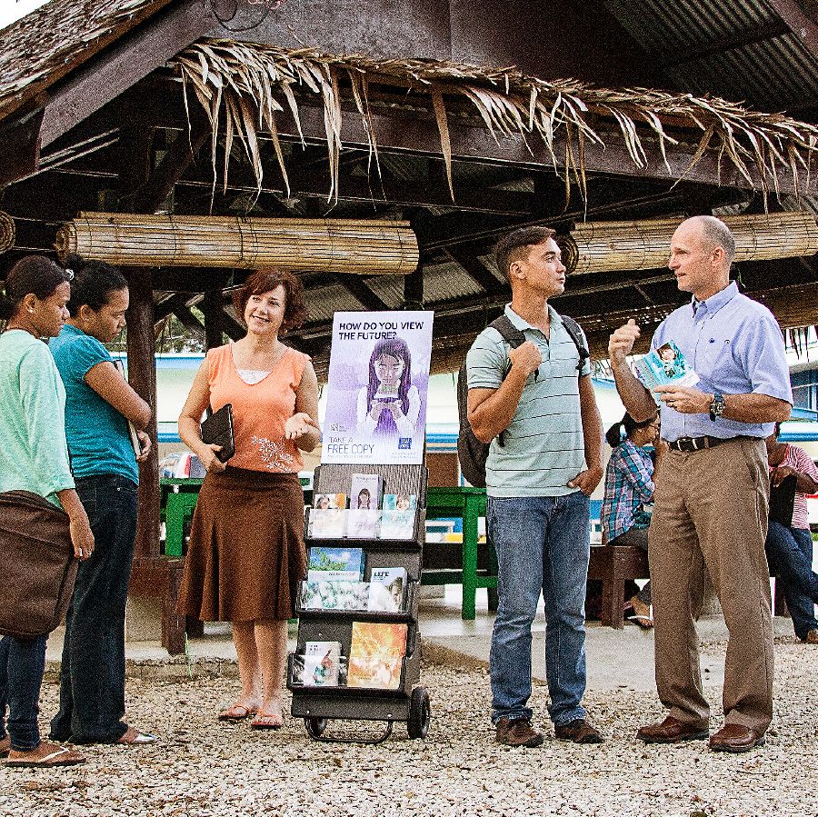 Misyonaryong si Roxanne ug Brian nga nakig-estorya sa mga estudyante tupad sa cart sa literatura duol sa kolehiyo sa Palau