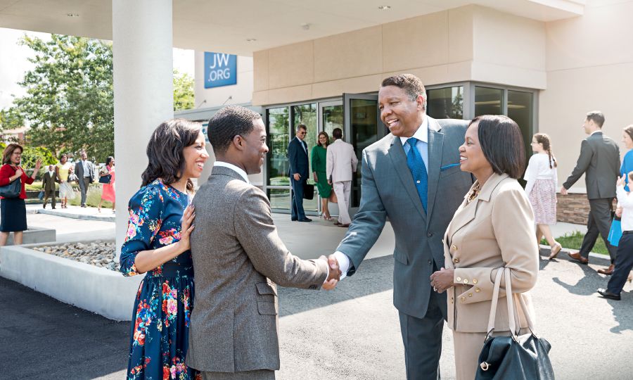 Jehovahʼs Witnesses greet one another outside a Kingdom Hall