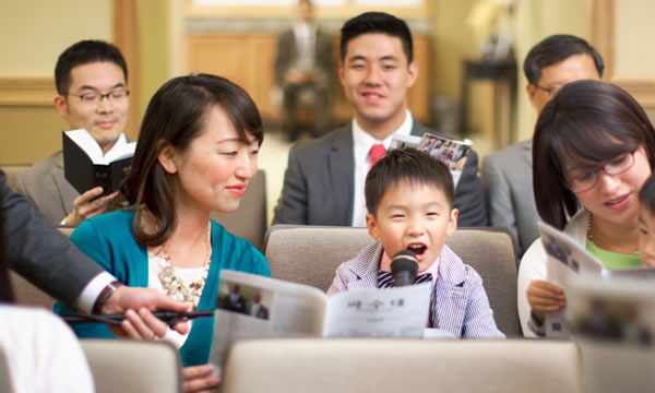 姊妹在聚會裡教身旁的小孩答問題