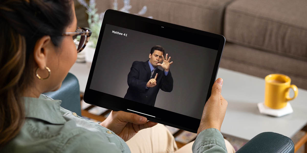 Sestra se na tabletu dívá na video s biblickým veršem ve znakovém jazyce