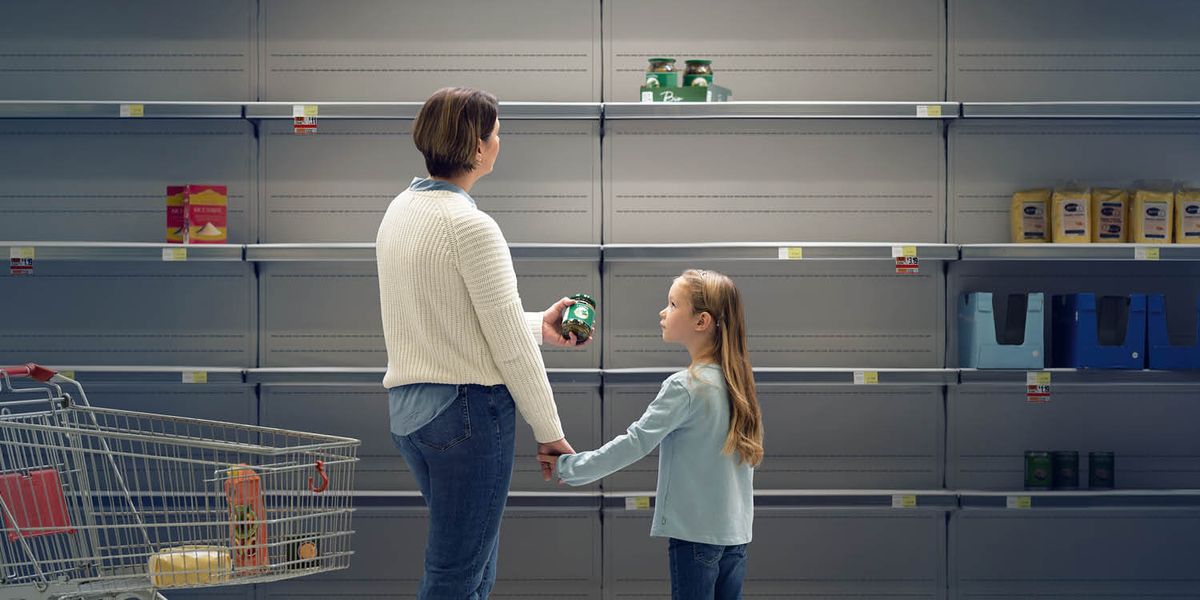 Maminka s dcerou si prohlíží prázdné regály v supermarketu