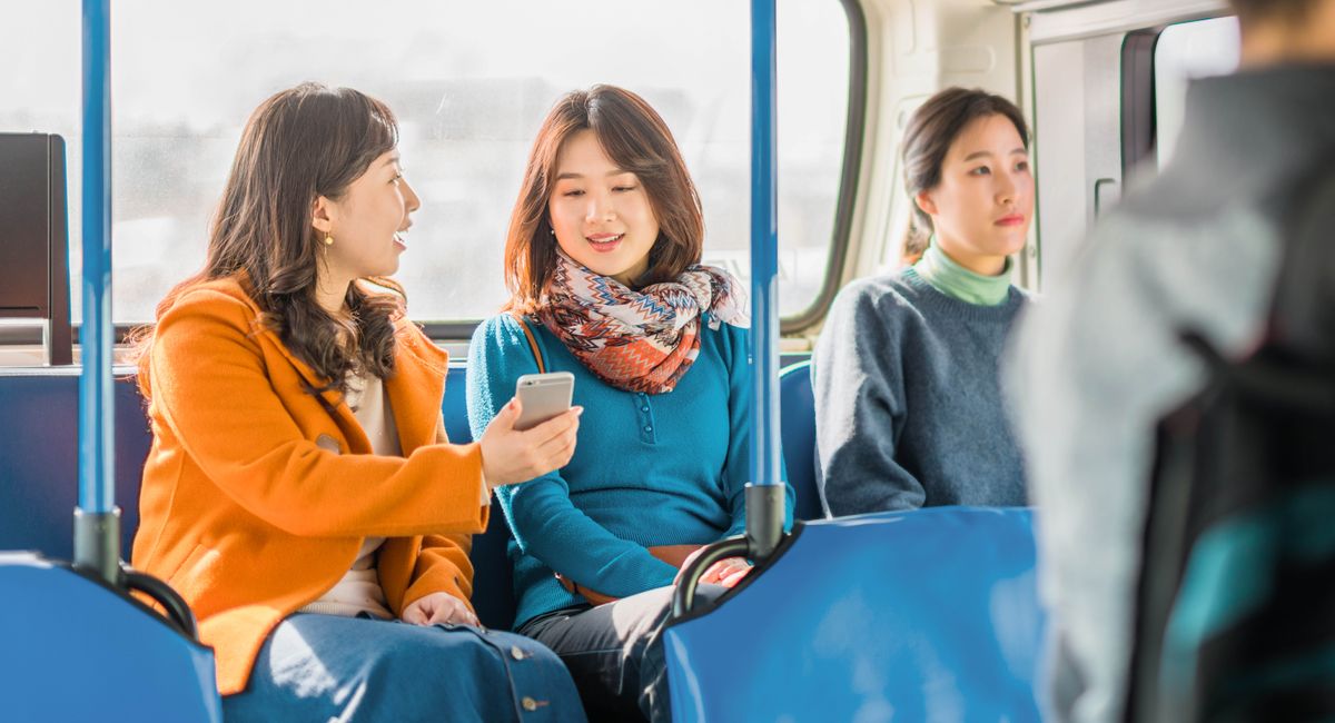 Sestra vydává s autobuse svědectví ženě a ukazuje jí něco na telefonu