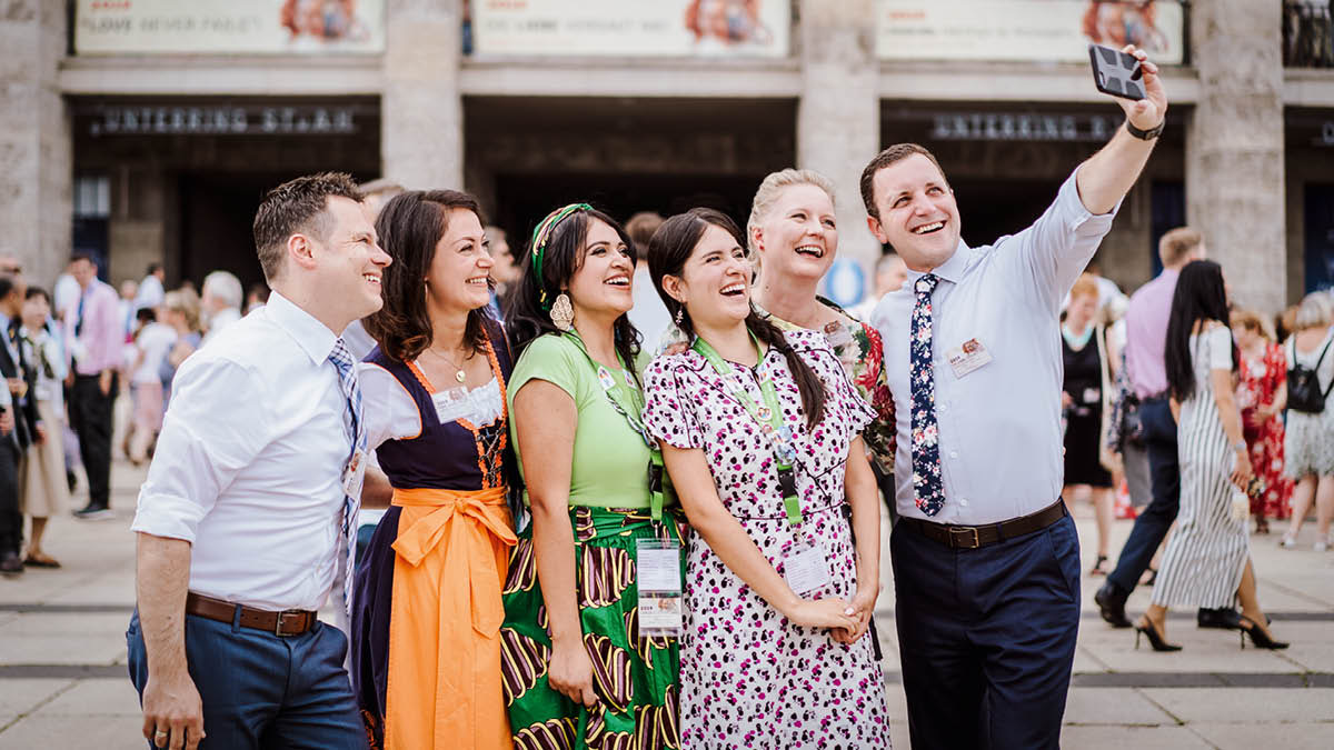 Veselá skupina bratrů a sester z různých zemí si na sjezdu dělá selfie