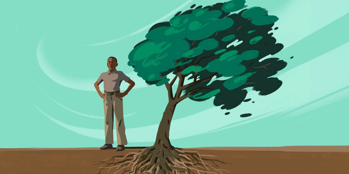 Un joven se mantiene firme junto a un árbol doblado por el viento