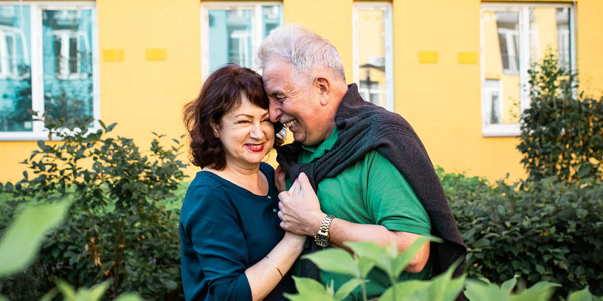 Un matrimonio mayor se abraza.