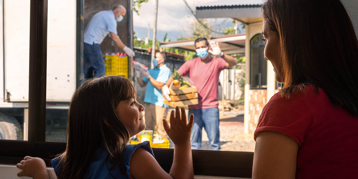 Algunos hermanos llevan suministros a una madre y su hijita.