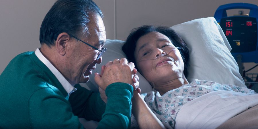 Un cristiano ora con su esposa, que está hospitalizada