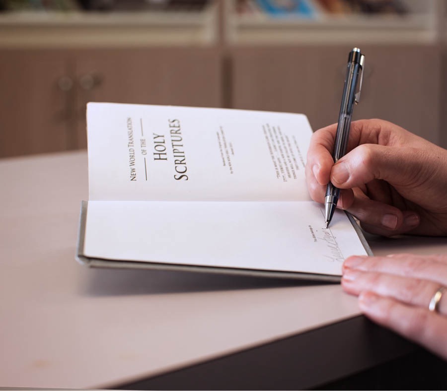 Un testigo de Jehová escribiendo su nombre en su Biblia