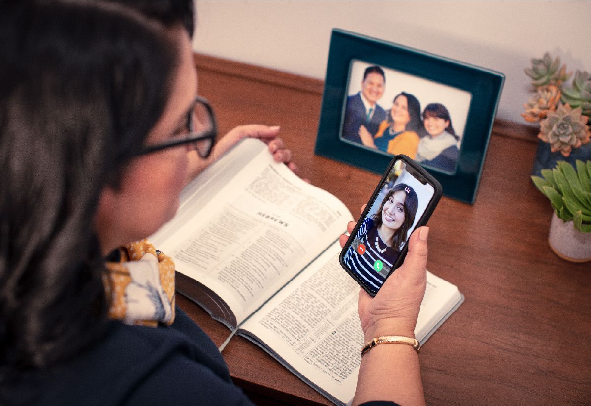Una hermana mirando la foto de un familiar expulsado en su teléfono