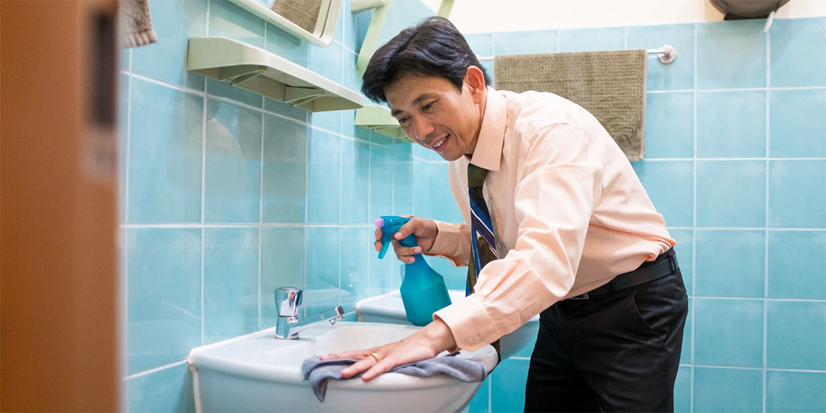 Un hermano limpiando los baños de un Salón del Reino