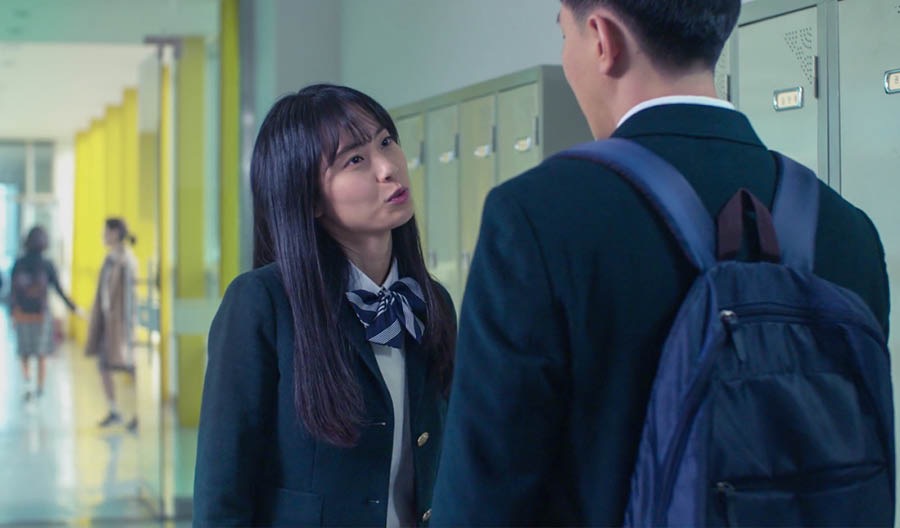 Mee-Kyong hablando con Jin en un pasillo de la escuela