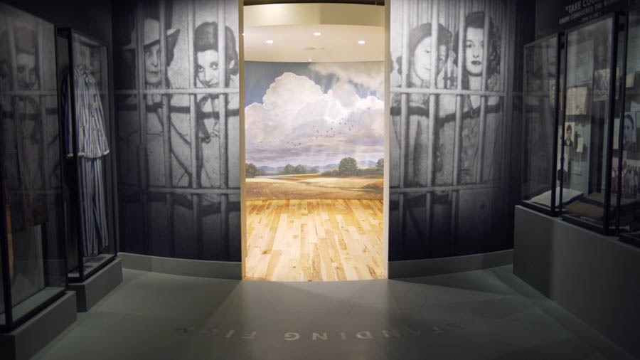 Exposición con fotografías de Testigos encarcelados por su fe. Puertas que llevan a una sala con imágenes del Paraíso