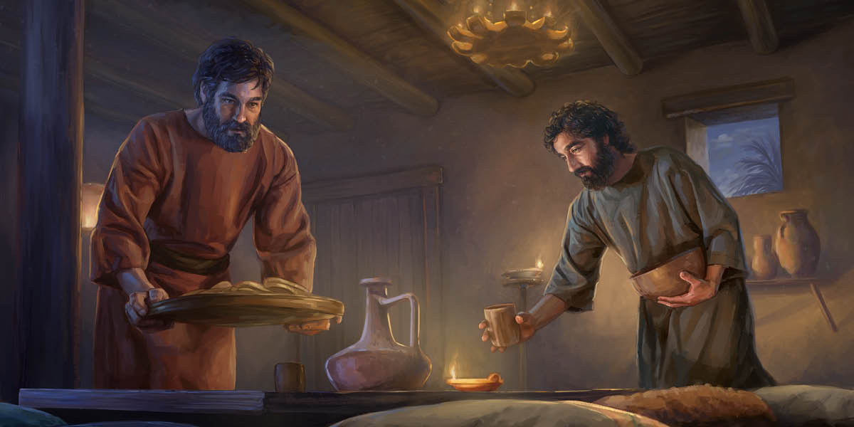 Pedro y Juan ponen el pan y las copas en la mesa.