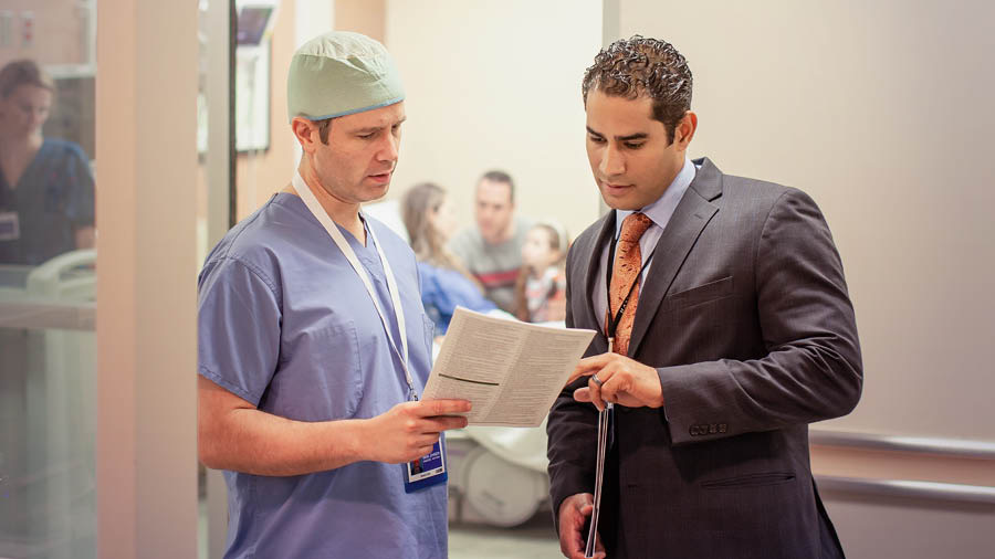 Un hermano del Comité de Enlace con los Hospitales le entrega información médica a un doctor.