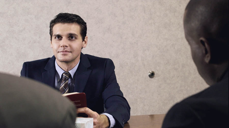 Una imagen del video Jehová disciplina a quien ama. Canon hablando con los ancianos cuando era un joven adulto.