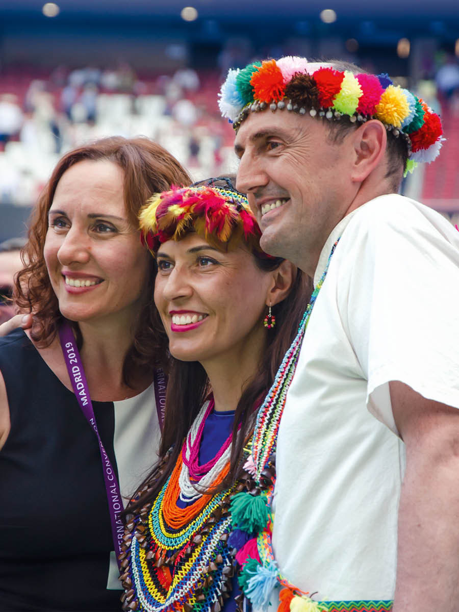 Delegados de diferentes culturas tomándose una foto en una asamblea internacional.