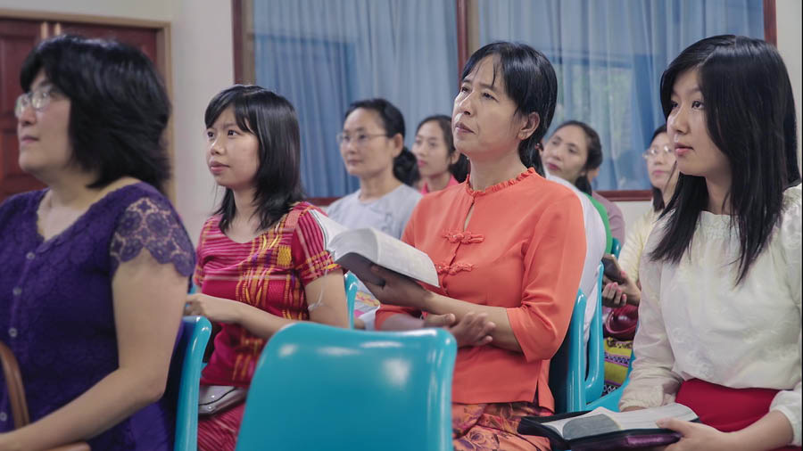Una imagen del video Mostremos en la congregación el amor que nunca falla: A las viudas y a los huérfanos. La hermana Myint y una de sus hijas en una reunión de congregación.