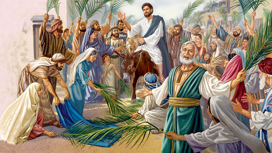 Jesús va montado en un burro. Una multitud extiende sus mantos y ramas de palmera en el camino.