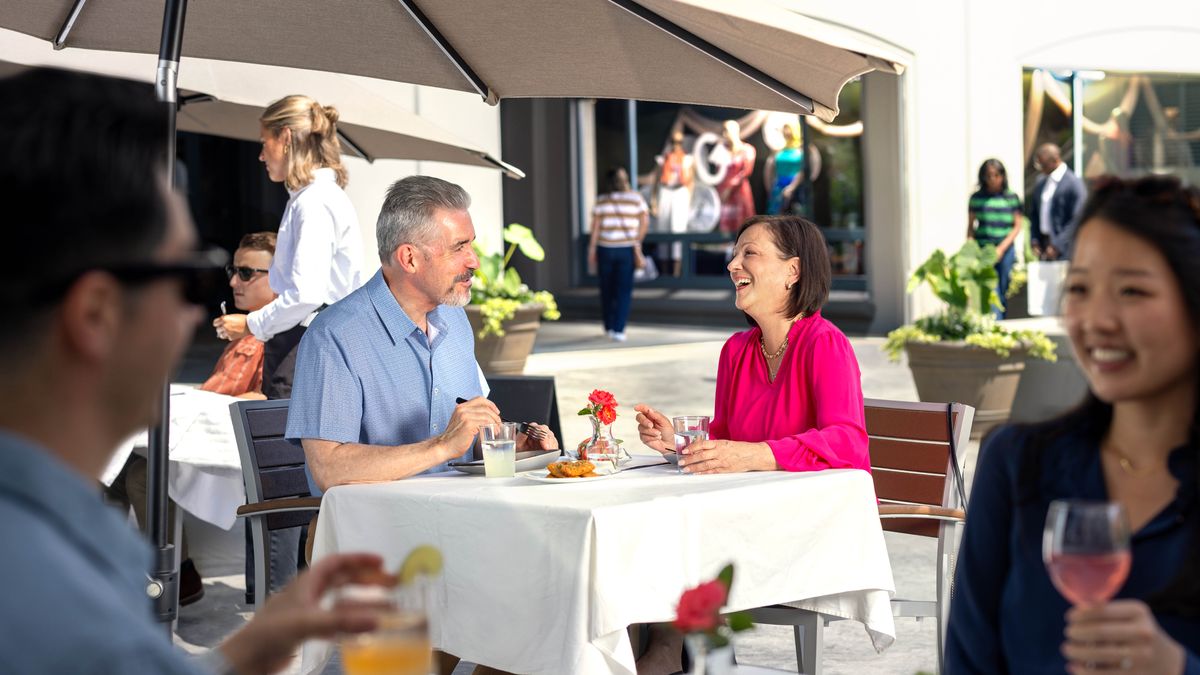 Una pareja de novios de mediana edad conversan alegres mientras comen en un restaurante.