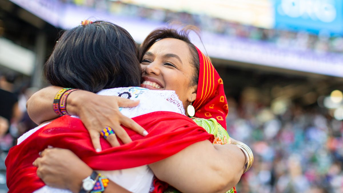 Dos hermanas se abrazan en una asamblea regional.