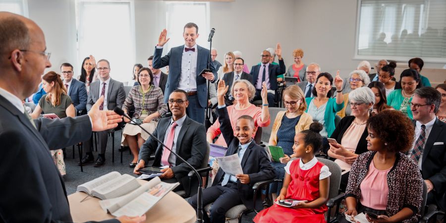 Una congregación alaba a Jehová comentando en la reunión
