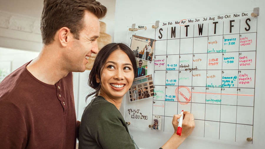 El matrimonio escribe sus metas espirituales en un calendario de pared.