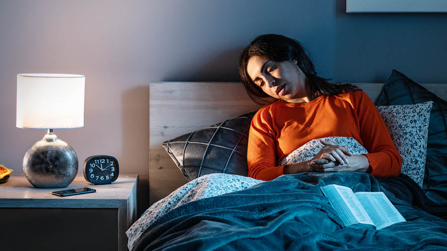 Una hermana se queda dormida mientras ora tumbada en la cama.