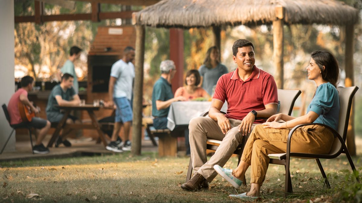 Dos novios están en una reunión social, sentados juntos y teniendo una conversación privada.