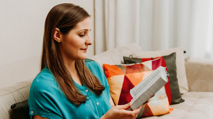 La mujer que antes recitaba oraciones de un libro, ahora lee la Biblia en su casa.