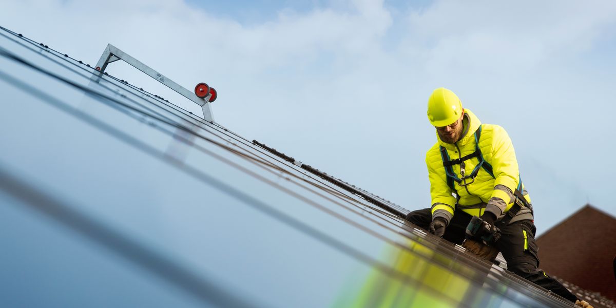 Un hermano instalando los paneles solares de un sistema fotovoltaico.