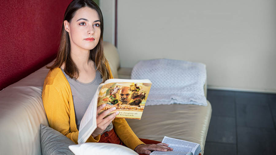 La hermana medita en lo que lee en la Biblia con la ayuda del libro “Testimonio cabal” del Reino de Dios.