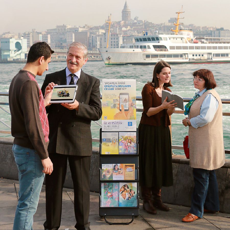 Zeugen Jehovas mit einem Trolley beim öffentlichen Zeugnisgeben