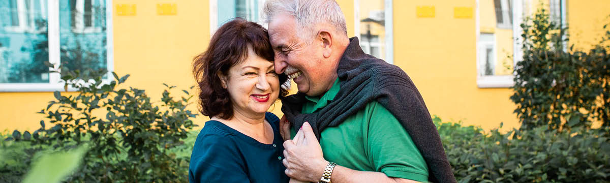 Un matrimonio mayor se abraza.