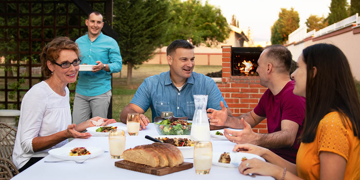 Un grupo de hermanos disfrutando al aire libre de una comida típica de Albania.