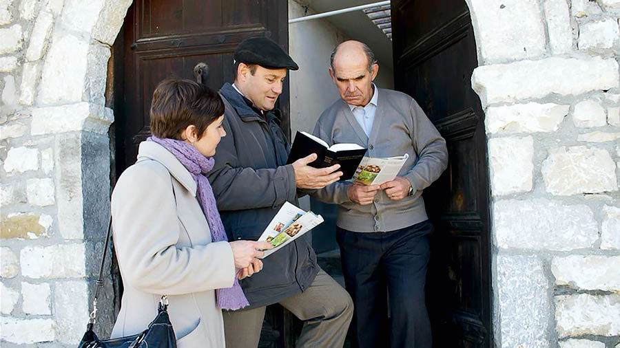 Miriam y Eliseo predicándole a un hombre en la puerta de su casa.