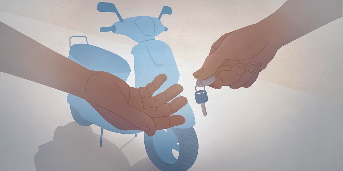 Alguien acaba de comprar una moto y el vendedor le entrega la llave. Al fondo se ve la moto.