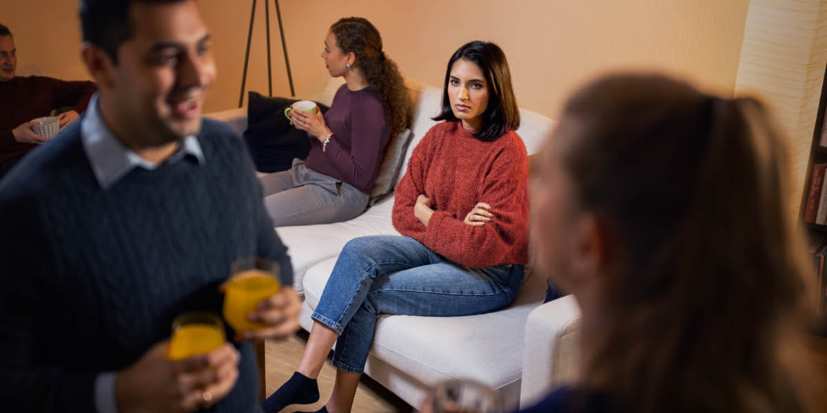 Una esposa siente celos al ver a su esposo hablando con otra mujer en una reunión social.