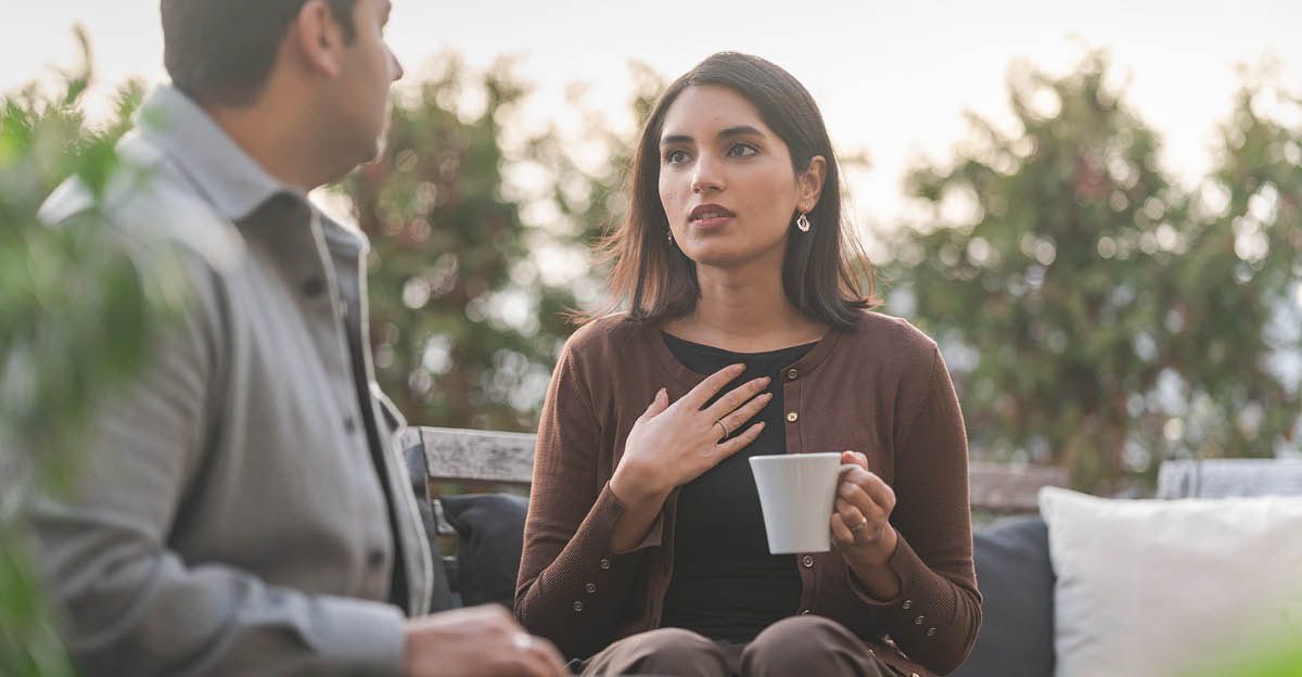 La esposa está sentada con su esposo al aire libre hablando de sus sentimientos con él.
