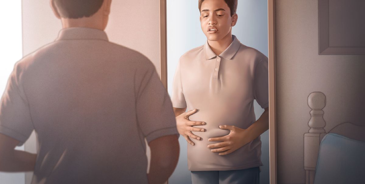 Un joven mirándose la barriga en el espejo