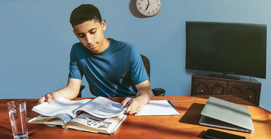 Un adolescente haciendo su tarea por la tarde y sin distracciones.