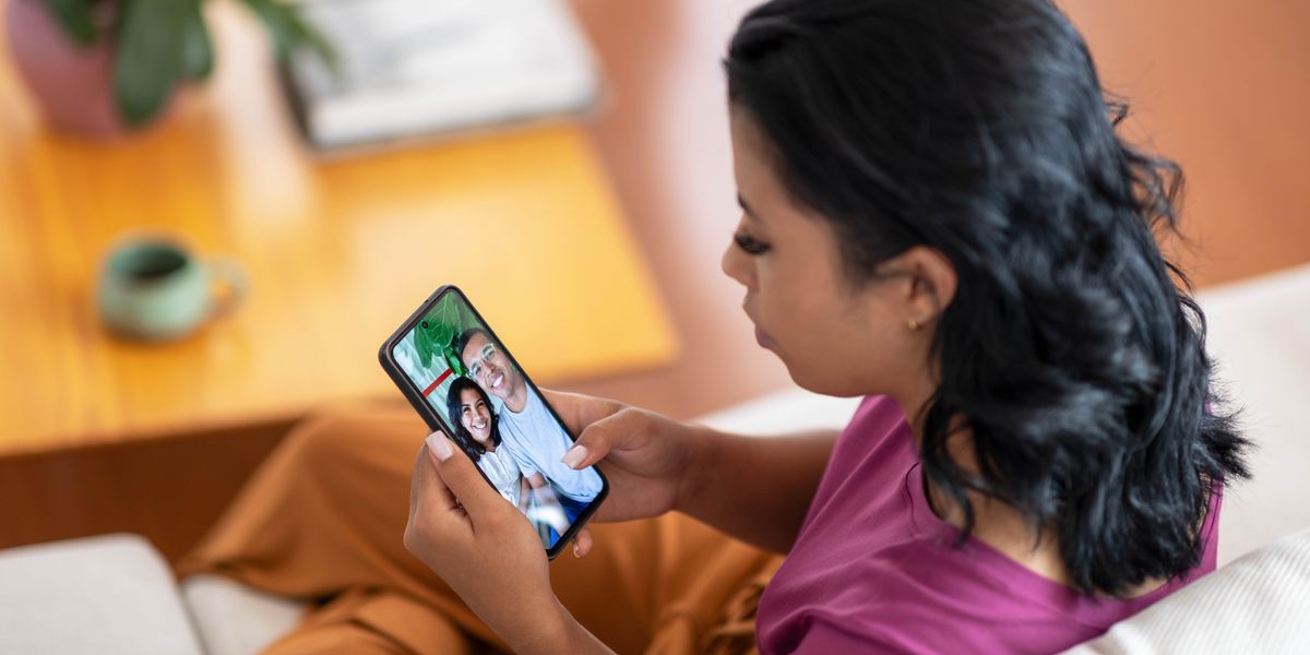 Una chica mirando una foto de ella con su novio en el teléfono.
