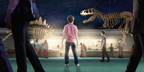 Estudiantes mirando esqueletos de dinosaurios en un museo